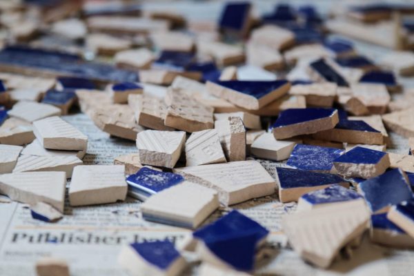 shattered blue tiles on a newspaper