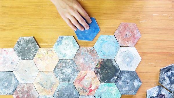 a person putting together hexagonal tiles