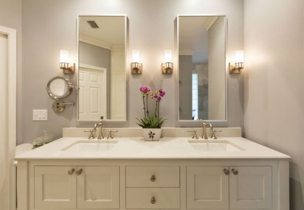 A well lit bathroom with a double vanity sink