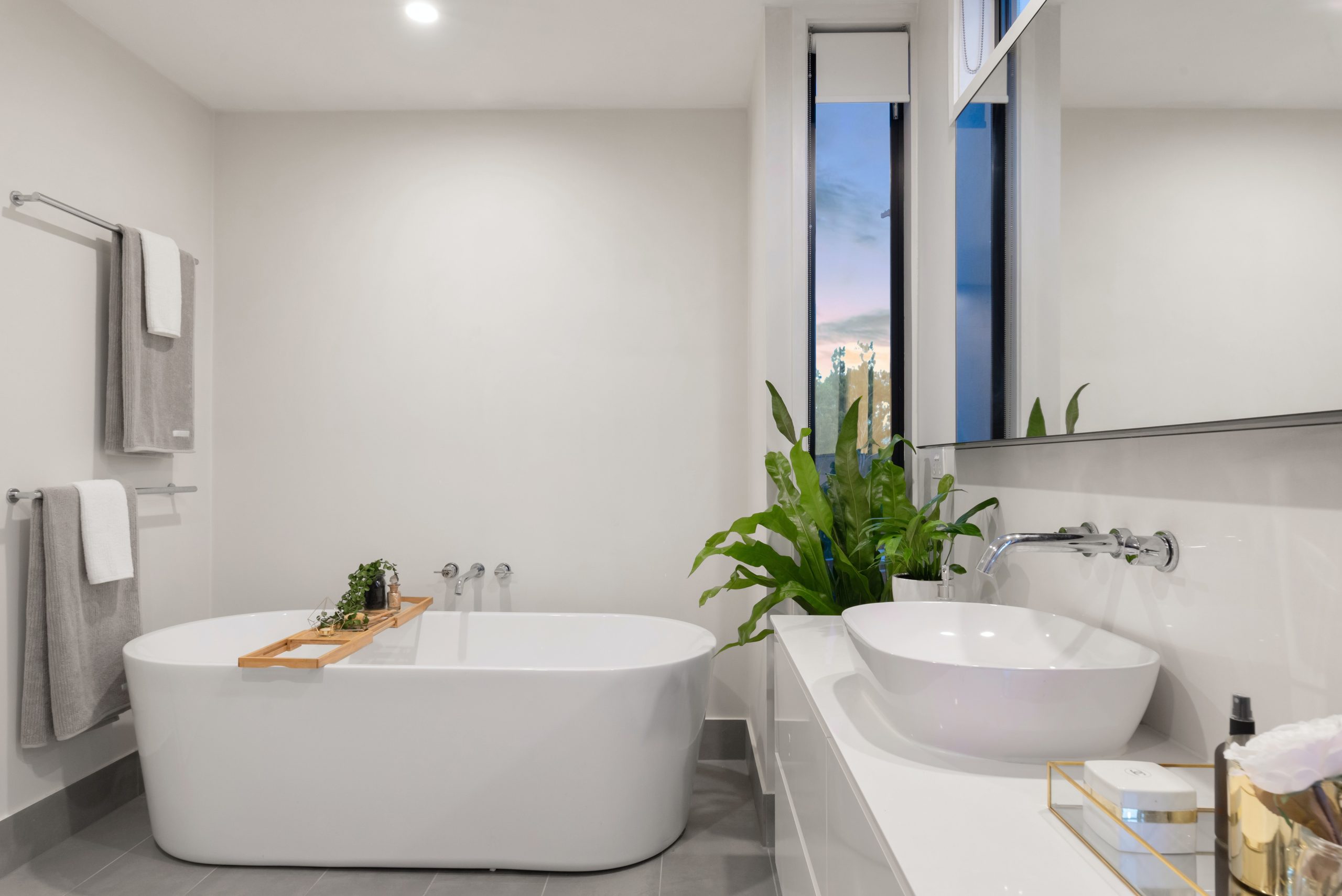 A photo of a bath with white walls and baths